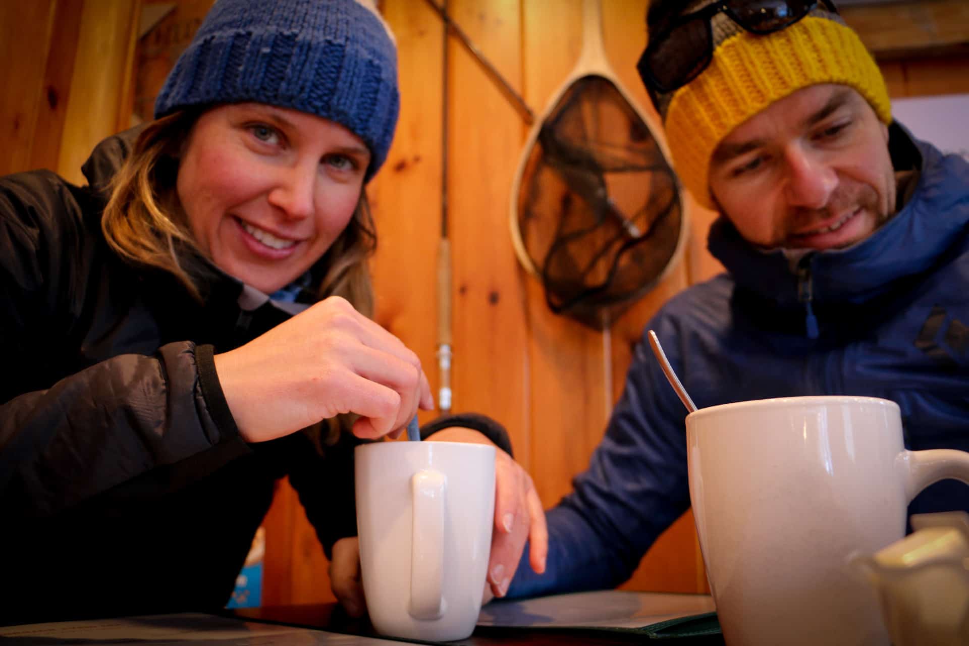 Afemale and a male smiling and drinking coffee after a fatbike ride